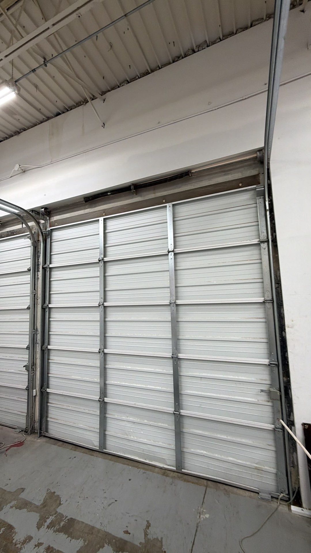 Tall insulated commercial overhead door installed inside a warehouse bay